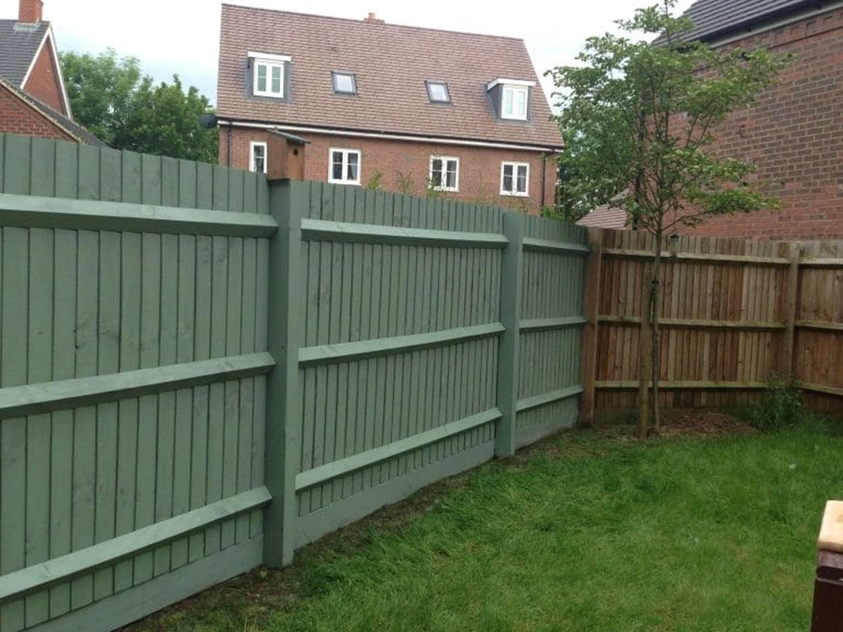 Green wooden fence painted by Lincoln Decorators in Lincoln