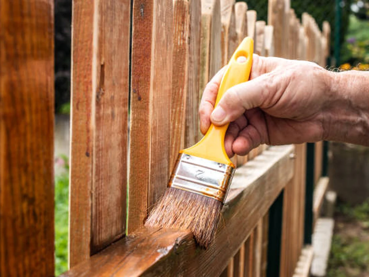 Hand brush applying fence paint on timber in Lincoln by Lincoln Decorators
