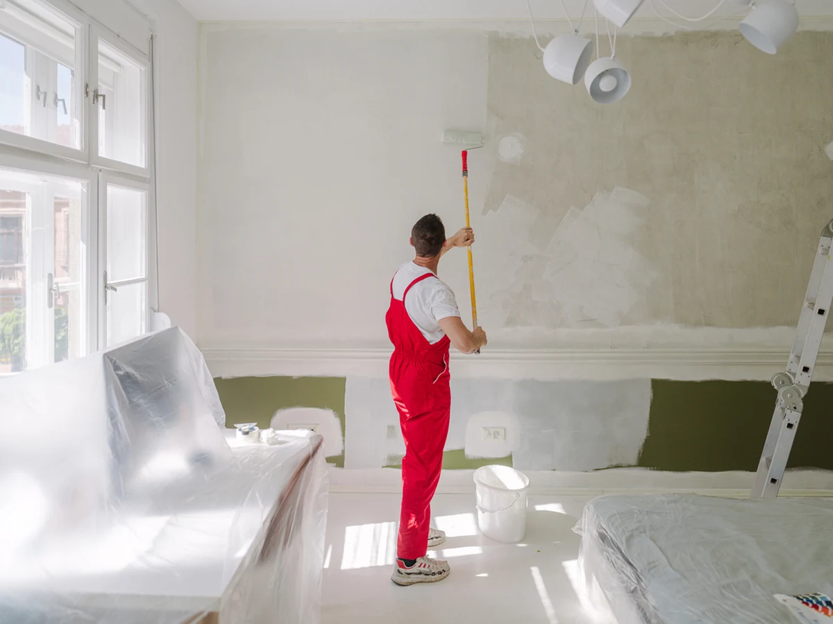 Painter in red overalls from Lincoln Decorators working on a property in Lincoln