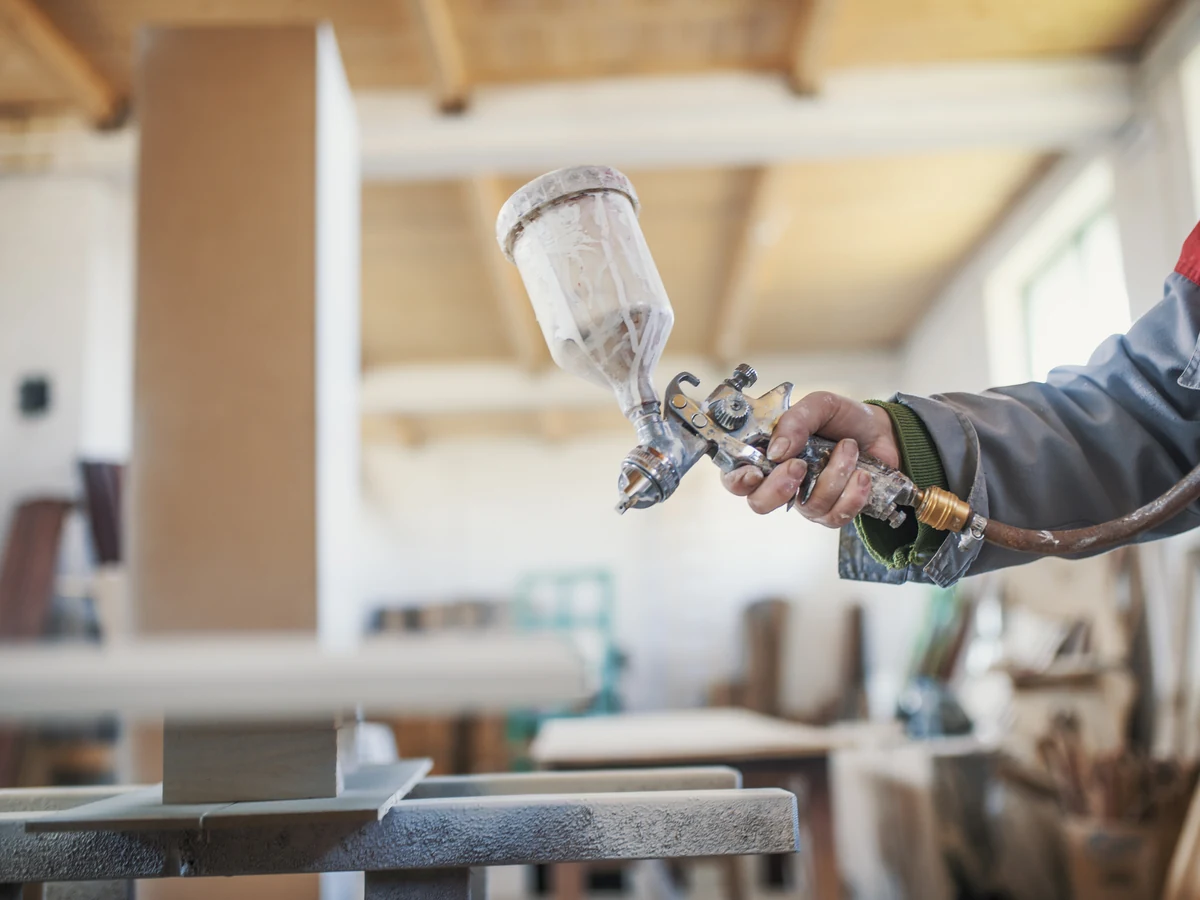 Decorator spraying surfaces during period property restoration as part of home renovation in Lincoln